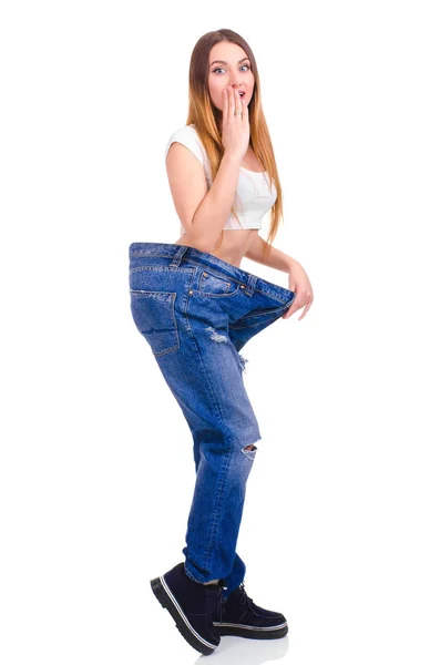 Junges Mädchen in blauen Jeans groß auf weißem Hintergrund — Stockfoto