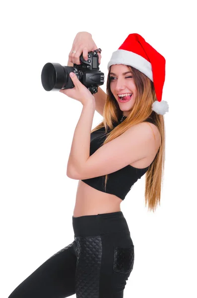 A rapariga do chapéu do Pai Natal com uma câmara. Jovem fotógrafa Natal. Selfie de Natal . — Fotografia de Stock