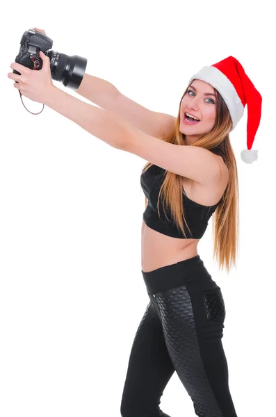 A rapariga do chapéu do Pai Natal com uma câmara. Jovem fotógrafa Natal. Selfie de Natal . — Fotografia de Stock