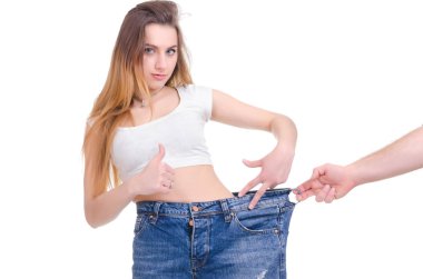  Diyet. Fitness. Genç kız beyaz zemin üzerine mavi kot pantolon büyük boyutunda