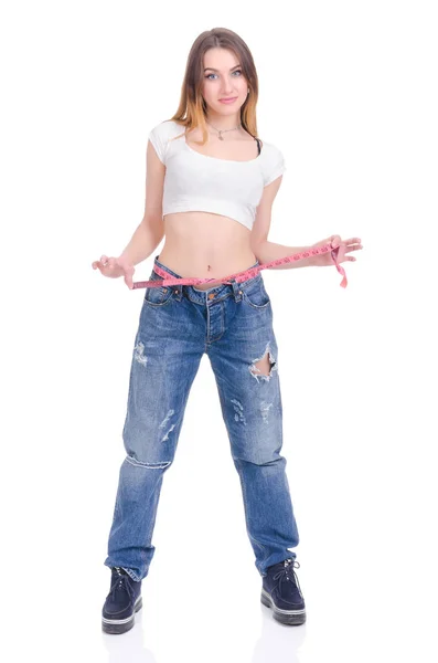Δίαιτα. Γυμναστήριο. Νεαρό κορίτσι σε μπλε τζιν μεγάλο μέγεθος σε λευκό φόντο — Φωτογραφία Αρχείου