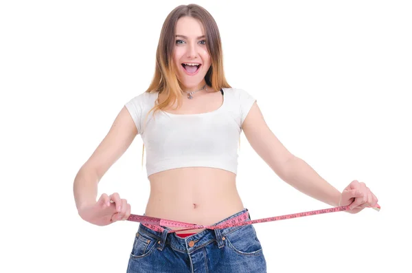 Ernährung. Fitness. junges Mädchen in blauen Jeans groß auf weißem Hintergrund — Stockfoto