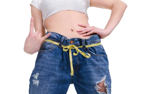 Ernährung. Fitness. junges Mädchen in blauen Jeans groß auf weißem Hintergrund — Stockfoto