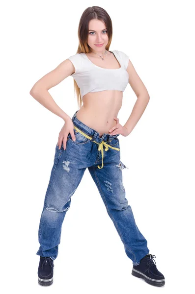 Δίαιτα. Γυμναστήριο. Νεαρό κορίτσι σε μπλε τζιν μεγάλο μέγεθος σε λευκό φόντο — Φωτογραφία Αρχείου