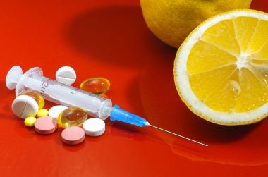 Limon ve şırınga kırmızı bir arka plan üzerinde. Vitamin ilaçları karşı. C vitamini.