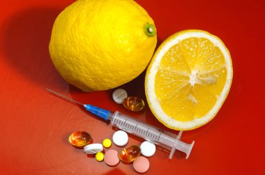 Limon ve şırınga kırmızı bir arka plan üzerinde. Vitamin ilaçları karşı. C vitamini.