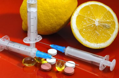 Limon ve şırınga kırmızı bir arka plan üzerinde. Vitamin ilaçları karşı. C vitamini.