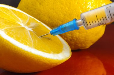 Limon ve şırınga kırmızı bir arka plan üzerinde. Vitamin ilaçları karşı. C vitamini.