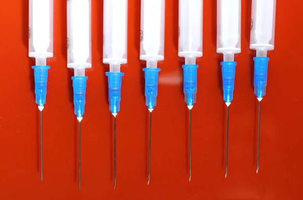 Syringe. Pills. Syringes with tablets on a red background. Injectors with medical preparations — Stock Photo, Image