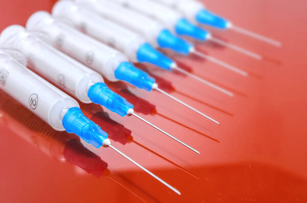 Syringe. Pills. Syringes with tablets on a red background. Injectors with medical preparations