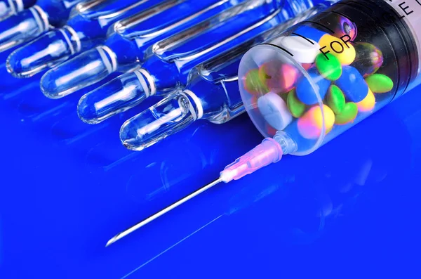 Syringe for subcutaneous injections with glass ampoules and multicolored tablets on an isolated background. Ampoule. Syringes.