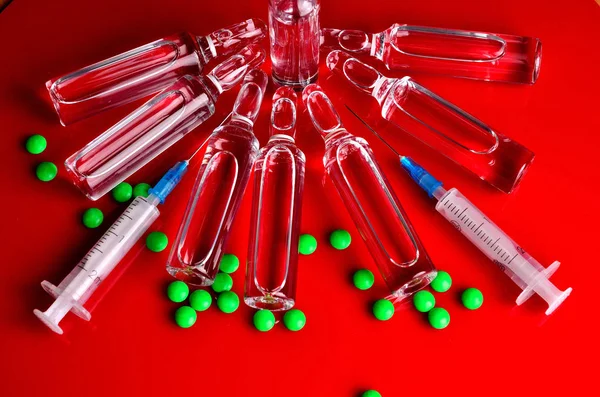 Syringe for subcutaneous injections with glass ampoules and multicolored tablets on an isolated background. Ampoule. Syringes.