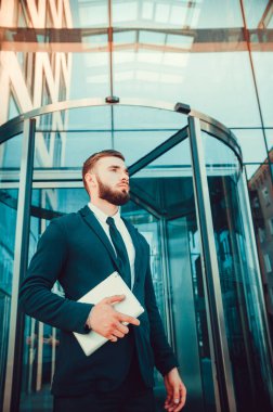 İş takım elbiseli genç bir adam üzerinde elinde bir tablet ile