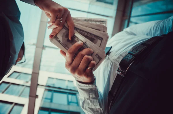 Bir kız bir erkek arka planda para elinde verir bir