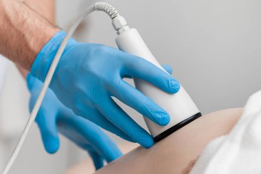 Ultrason boşluğu, vücut hatları, tedavi. RF kaldırma. Kadın anti-selülit ve anti-yağ terapisi görüyor.