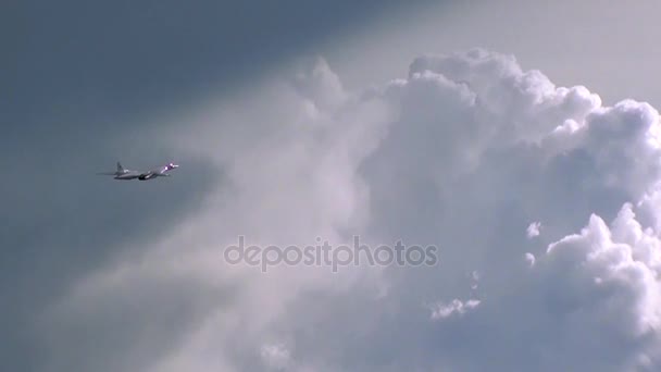 El avión vuela sobre un fondo de nubes cúmulos — Vídeos de Stock