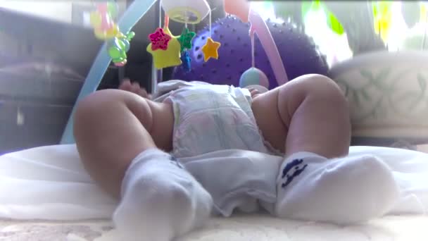 De baby beweegt haar benen in sokken — Stockvideo