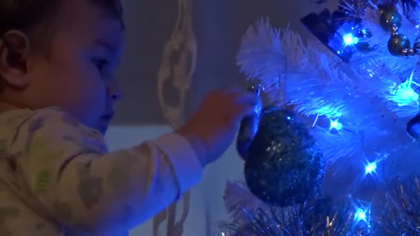 Baby spielt mit Weihnachtsdekoration — Stockvideo