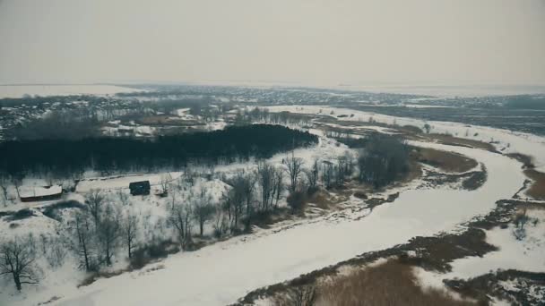 Беспилотник падает над замерзшей рекой — стоковое видео
