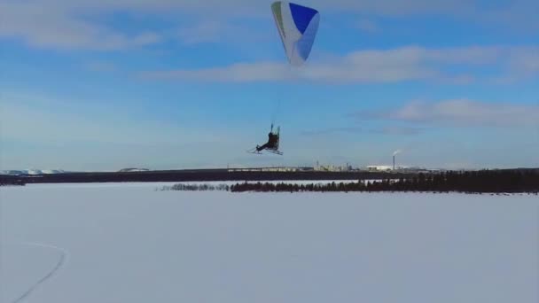 Een aangedreven paraglider vliegt in een cirkel — Stockvideo