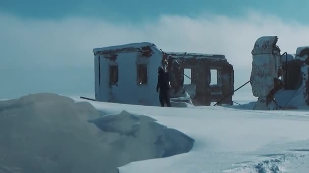Un uomo cammina tra le rovine della neve — Video Stock