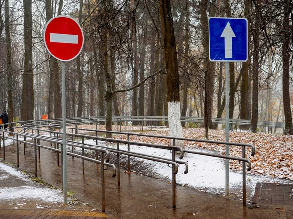 Camino, mojado después de la nevada, en el parque con una protección para la ayuda — Foto de Stock