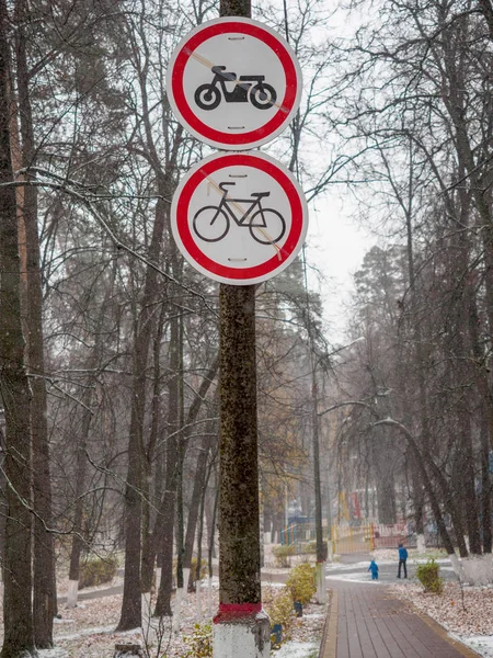 Camino, mojado después de las nevadas, en el parque con señales de prohibición para los motociclistas — Foto de Stock