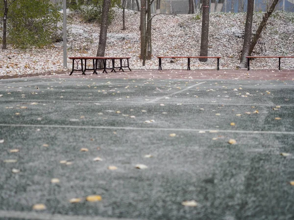 The empty platform in the park for playing volleyball and tennis after the first snowfall