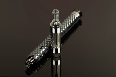Elektronik sigara (vape) siyah bir arka plan karşı sıralanmış konum.