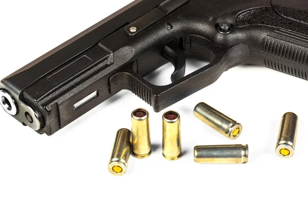 La pistola nera e le cartucce a lui su uno sfondo bianco — Foto Stock