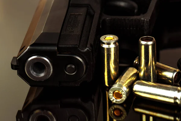 De zwarte pistool en cartridges aan hem close-up. — Stockfoto