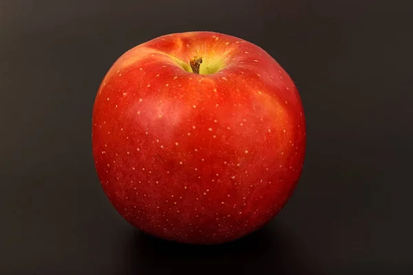 Bir kırmızı olgun elma bir siyah yakın çekim — Stok fotoğraf