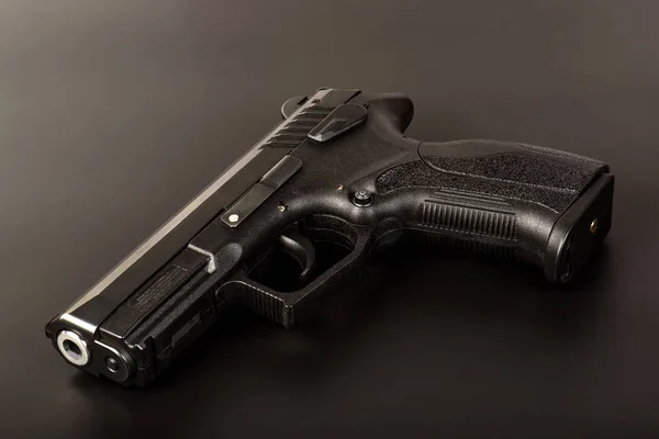 The black gun (pistol) on a dark background close up