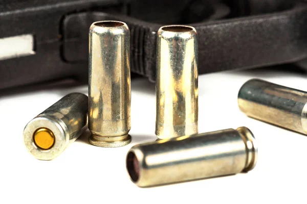 De zwarte pistool en cartridges aan hem op een witte achtergrond — Stockfoto