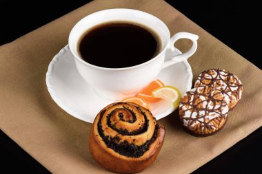 Bir fincan kahve ve kurabiye yakın.