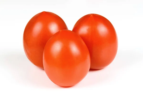 Tři červené zralé rajče zblízka na bílé — Stock fotografie