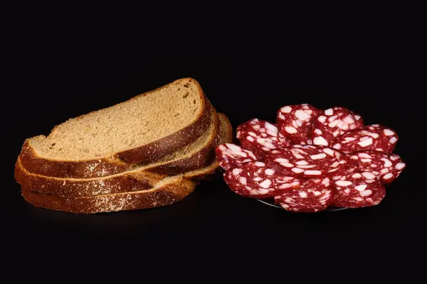 Salchicha ahumada y pan sobre un negro — Foto de Stock