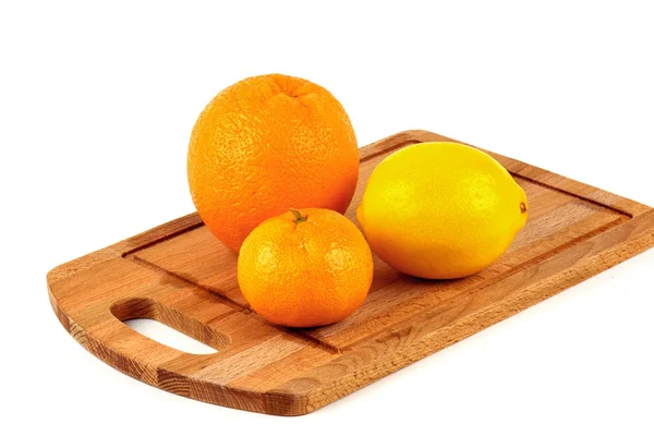 Mandarina, limón y naranja en una tabla de cortar de madera —  Fotos de Stock