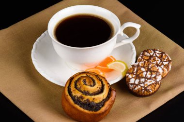 Bir fincan kahve ve kurabiye yakın.