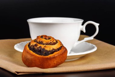 Bir fincan kahve ile bir siyah haşhaş tohumu çörek