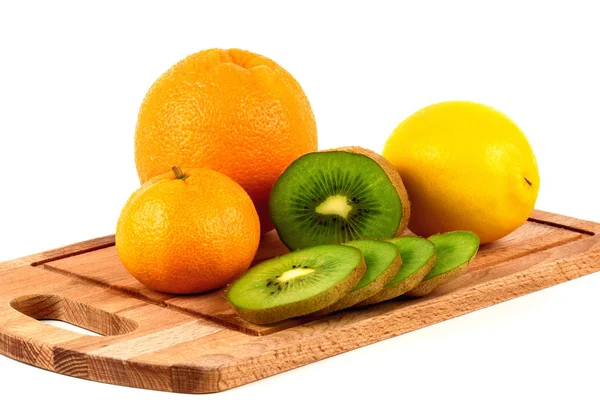 Mandarin, lemon, orange and kiwi on a wooden cutting board — Stock Photo, Image
