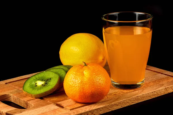 Mandarin, kiwi, lemon and glass of juice — Stock Photo, Image