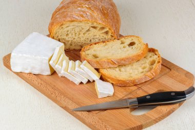 Kahvaltı ahşap oyun tahtası için dilimlenmiş peynir ve ekmek.