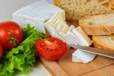 Ekmek, peynir, domates ve elim bir ahşap masa portre salataya üzerinden Servis Kahvaltı.