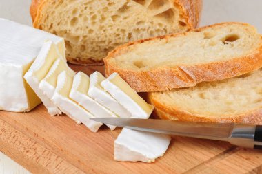 Kahvaltı ahşap oyun tahtası için dilimlenmiş peynir ve ekmek.