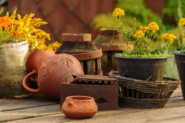 Tontopf, Korb mit Blumen auf einem Holztisch. Naturmot im alten Stil. — Stockfoto