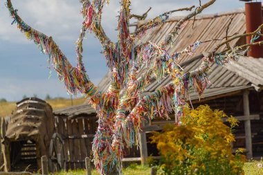 Bir ağaç bir eski ahşap gözetleme kulesi önünde renkli şeritler arzuların.