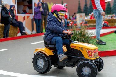 Rusya, Moskova, Ekim 2019. Moskova 'daki Kızıl Meydan' daki sonbahar hasat festivalinde oyuncak traktörlerle çocukları yarıştırmak.