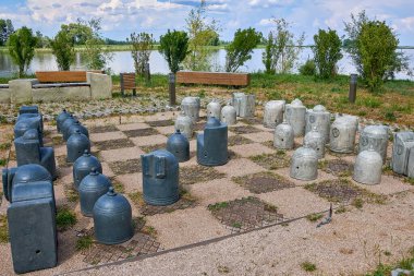 Yerde taş satranç taşları var. Parkta satranç taşları olan stilize satranç tahtası..