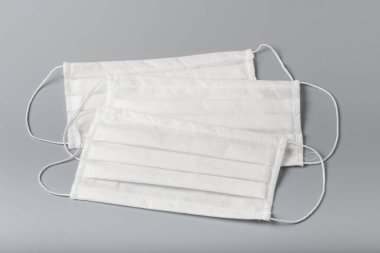 Gri arka planda beyaz tıbbi maskeler. Grip virüsünden korunmak için tıbbi maske.